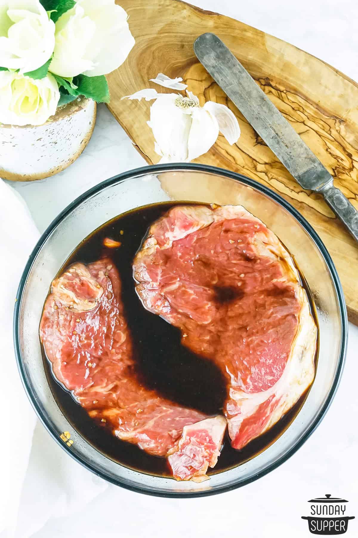 steak marinating in bowl