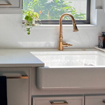 a porcelain sink under an open sunny window