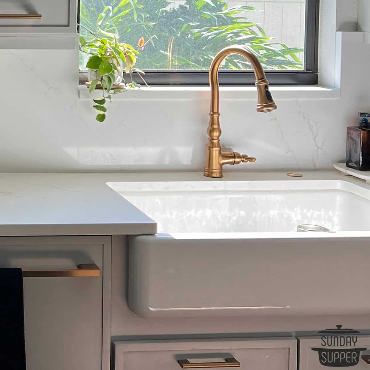 a porcelain sink with a golden faucet and a clean marble counter