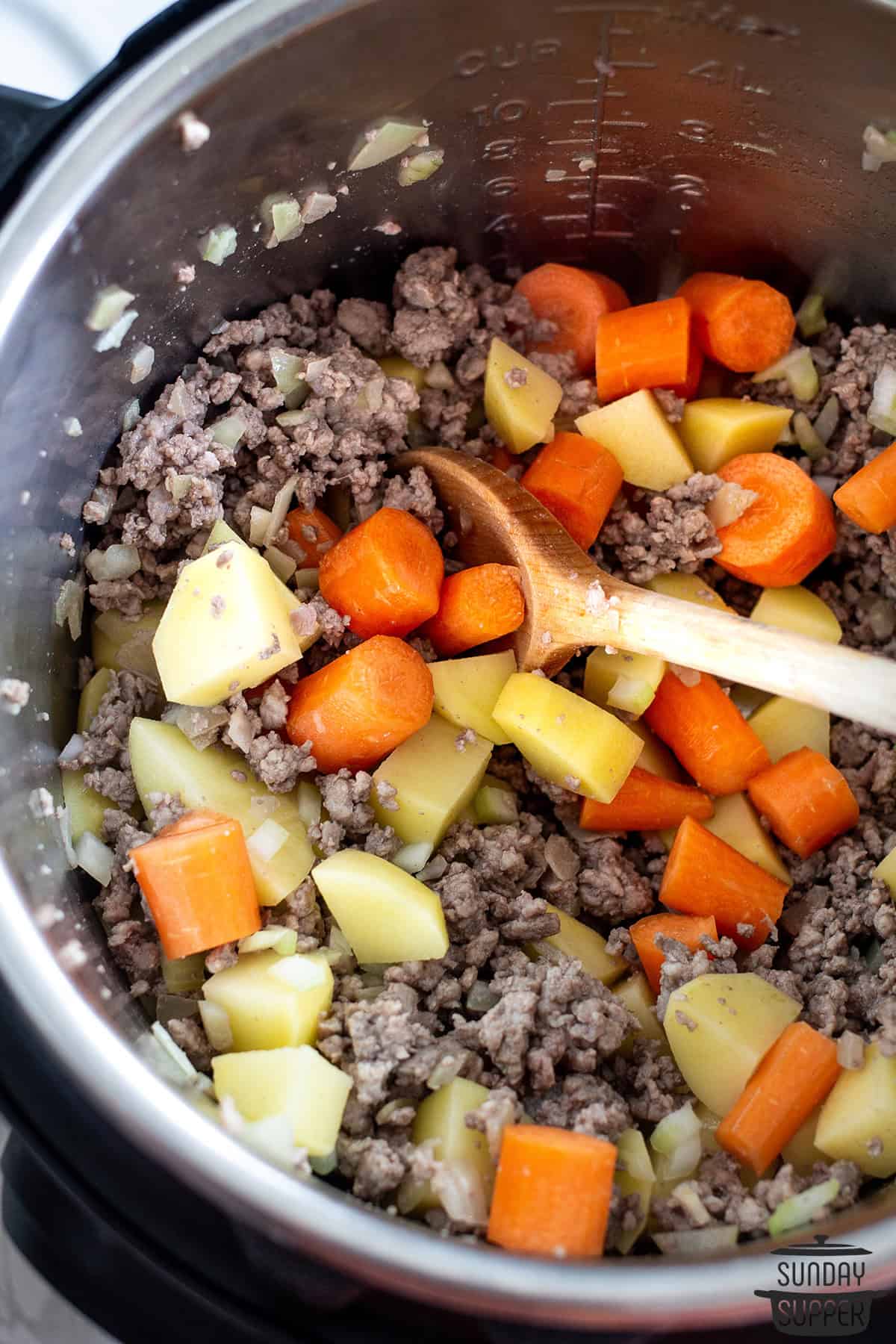 mixing vegetables into hamburger soup in instant pot