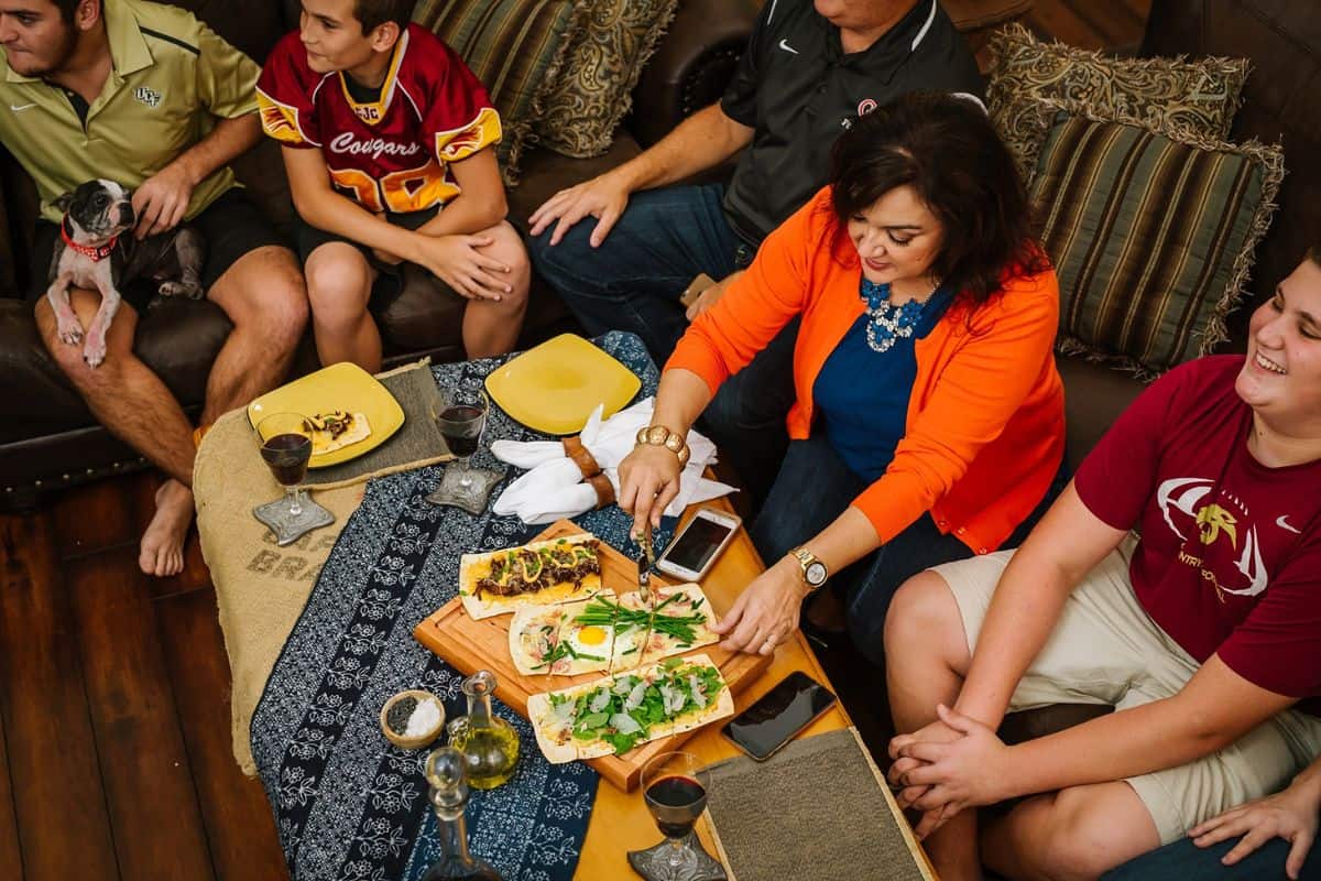 Isabel and her family enjoying a meal together on the couch