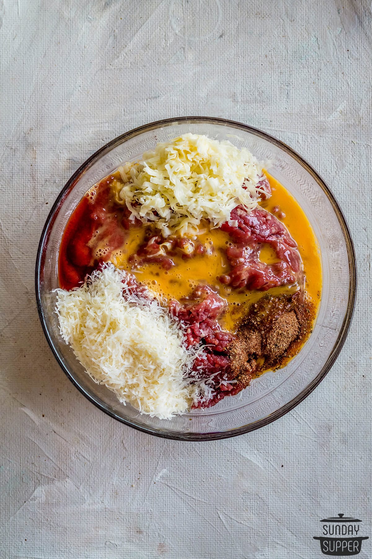 mixing keto meatloaf ingredients in a bowl