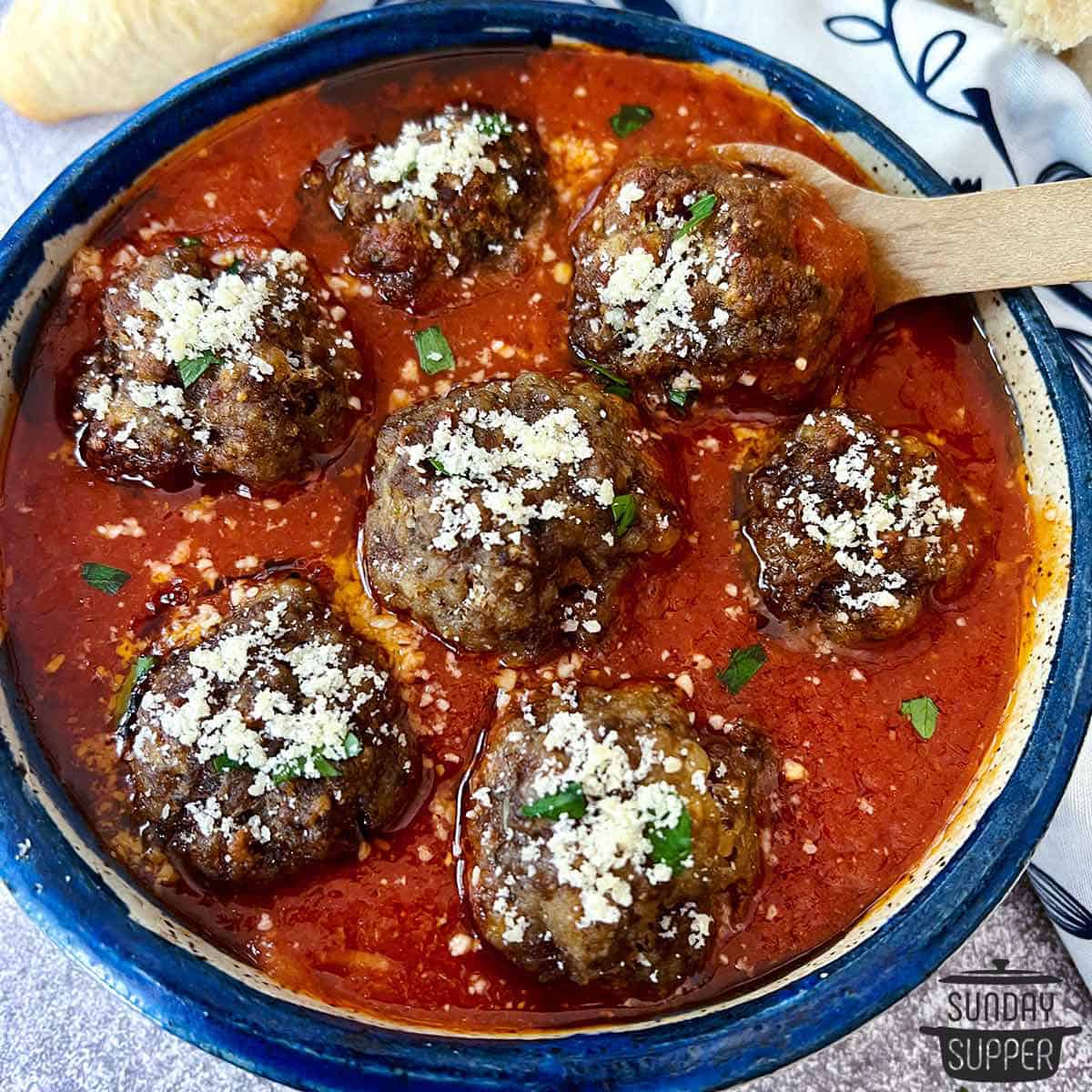 meatballs in sauce with parmesan on top