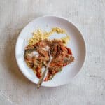 ingredients for meatloaf seasoning on a white plate with a spoon