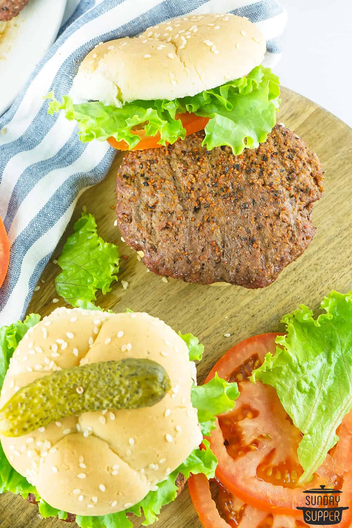 two smoked burgers on a serving board