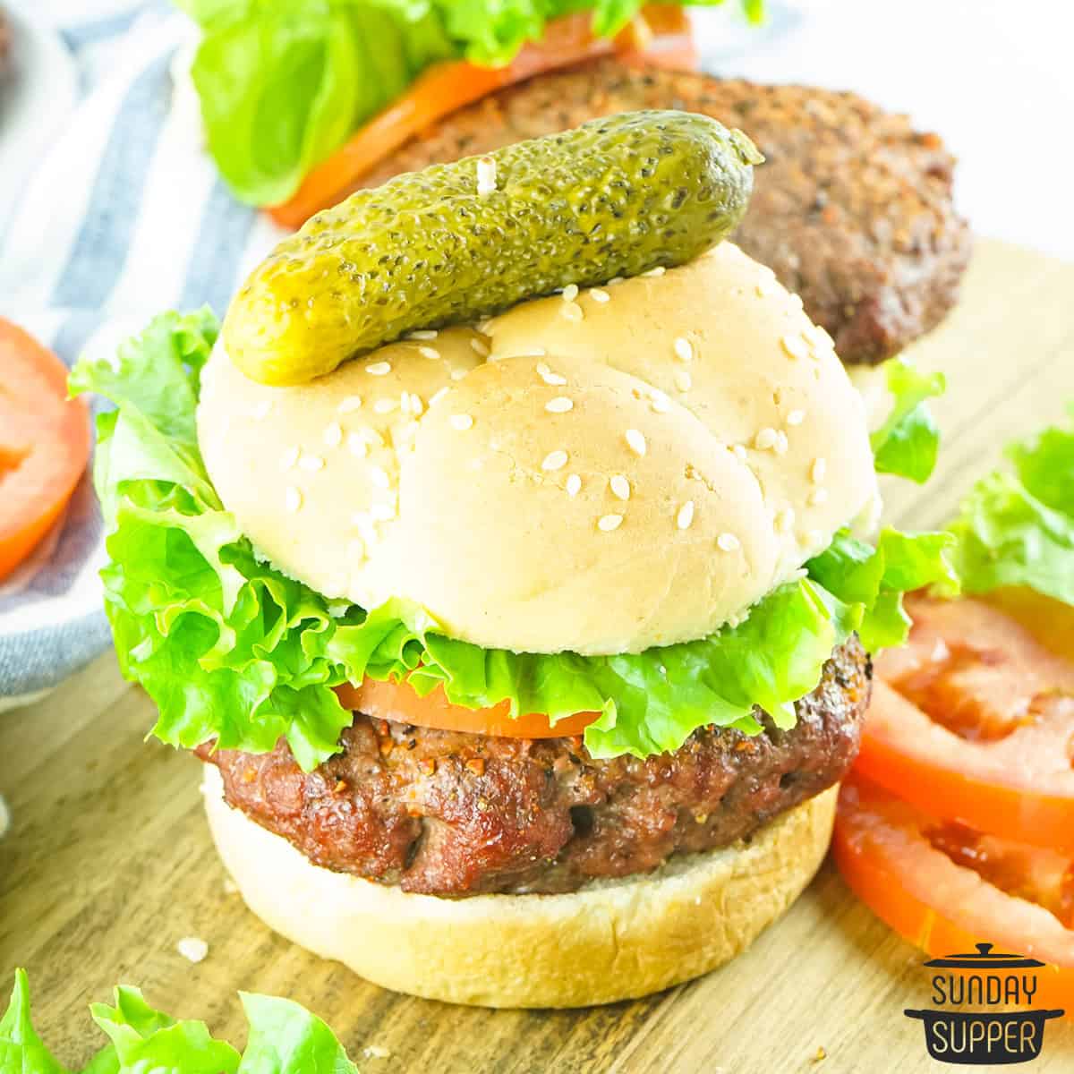 a smoked burger up close with tomato and lettuce