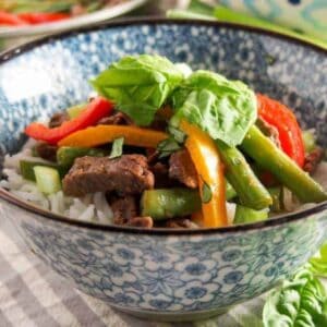 steak stir fry in a rice bowl with green beans