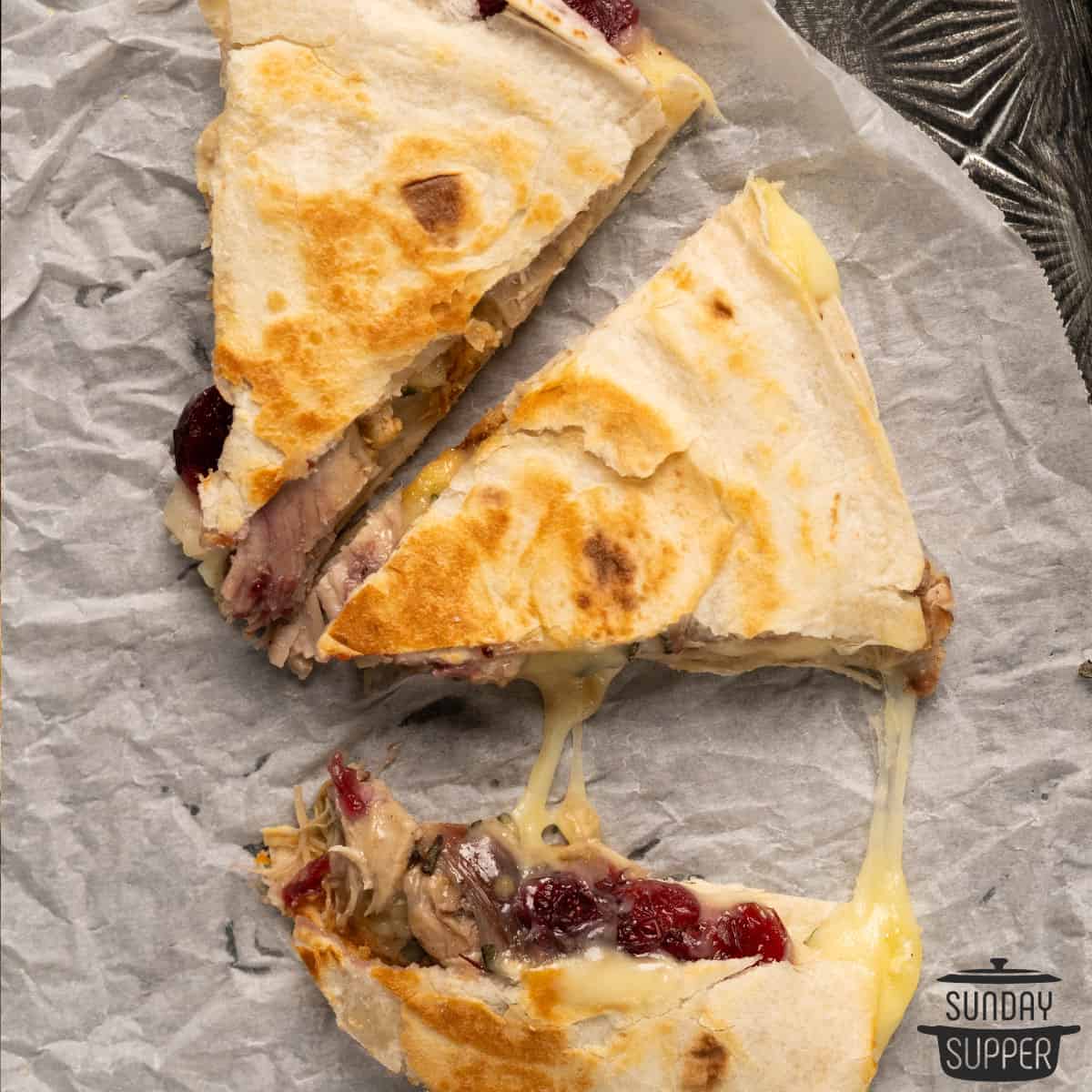 three slices of turkey quesadilla with cheese pulls