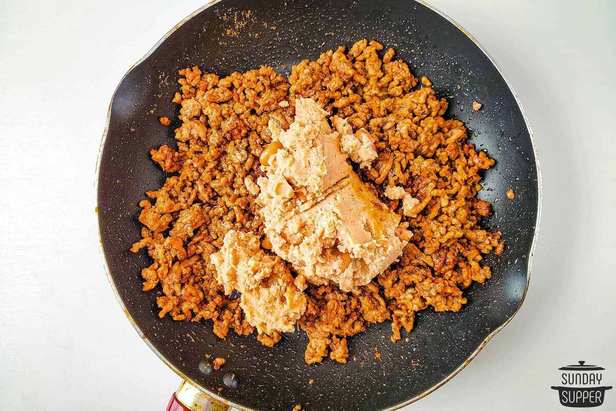 refried beans added to the pan of ground beef