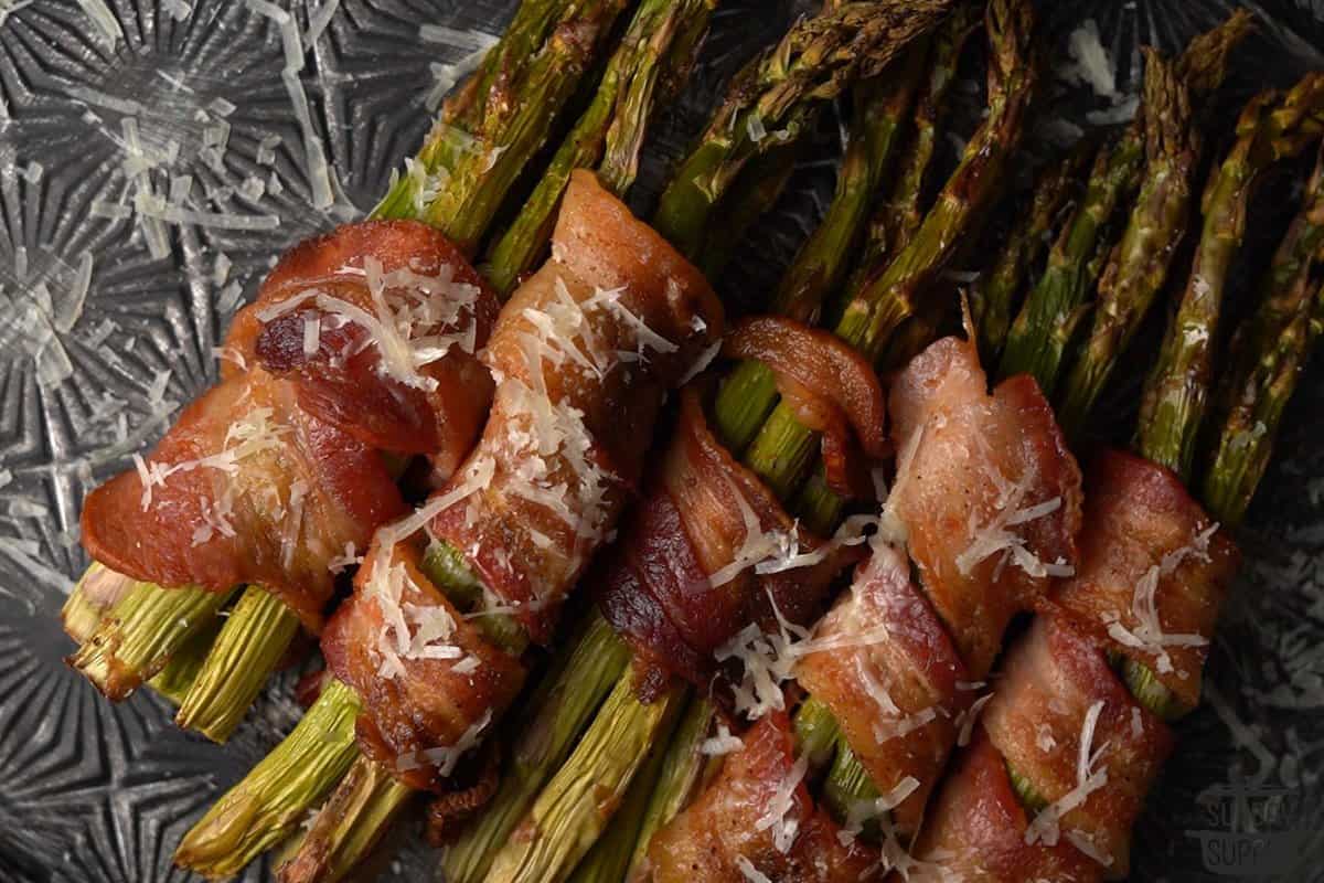 roasted asparagus wrapped in bacon with parmesan cheese on top