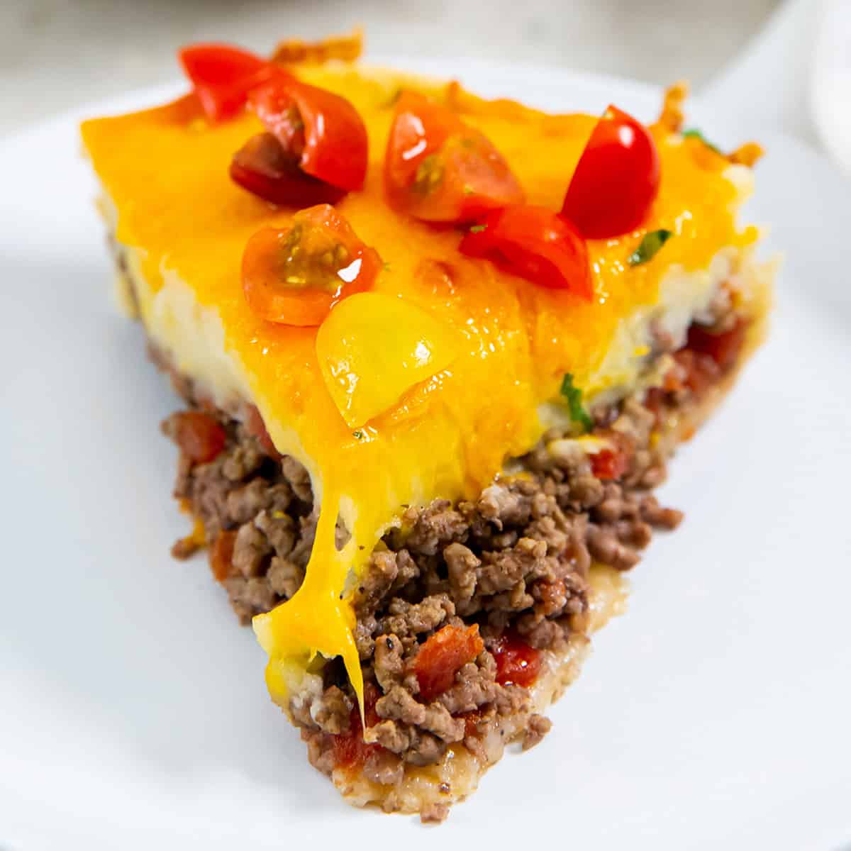 a front on view of a slice of cheeseburger pie