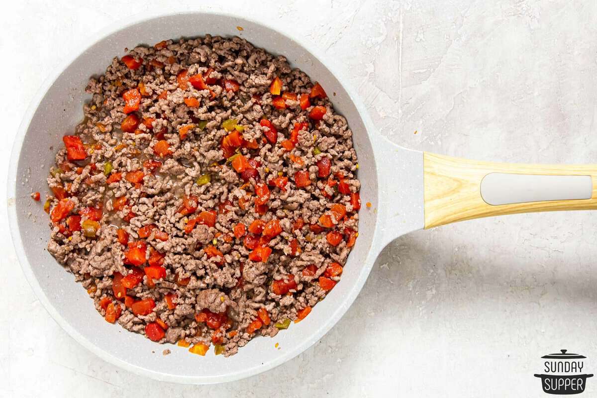 tomatoes with green chiles added to the pan of ground beef