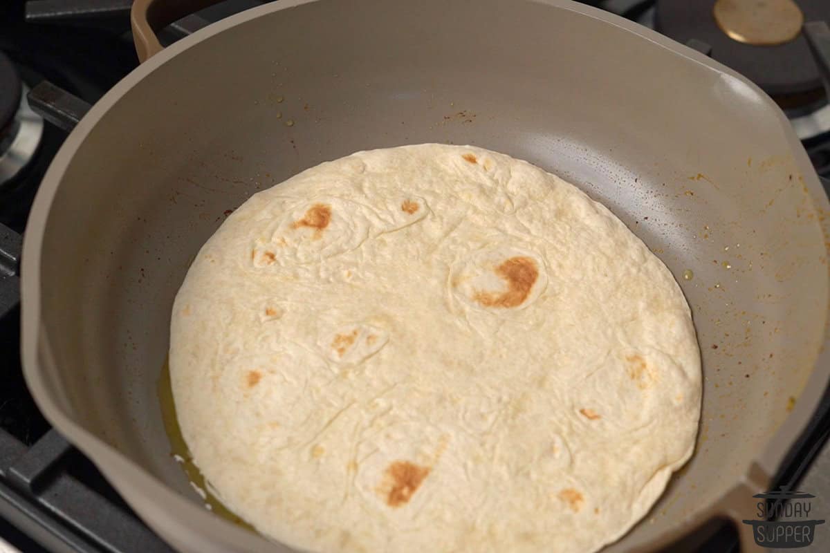 the tortilla added to the pan after the chicken and vegetables have cooked