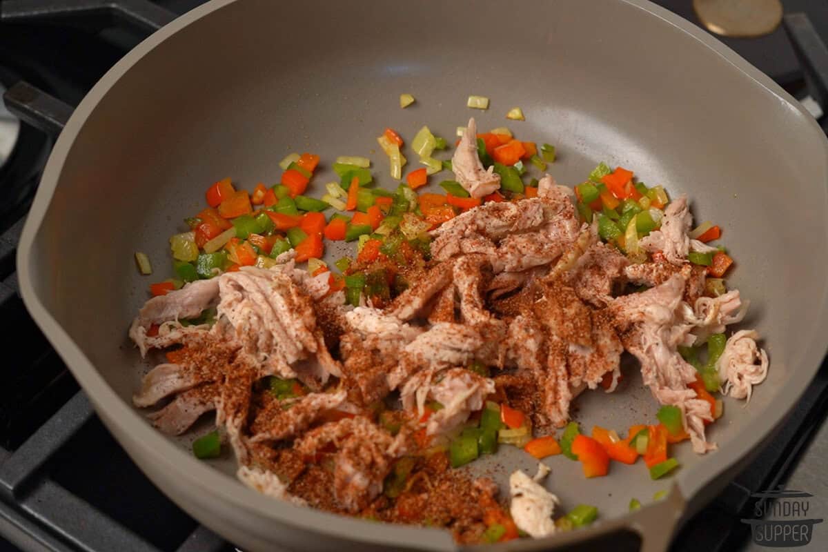 the chicken and seasonings added to the pan of veggies