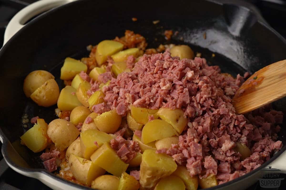 potatoes and corned beef added to the pan