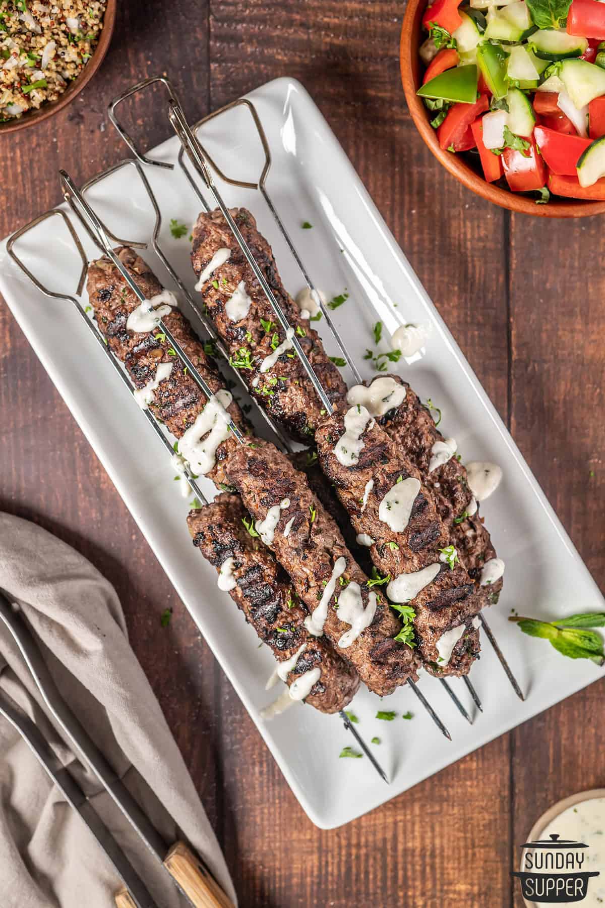 a platter of beef kebabs with garlic sauce