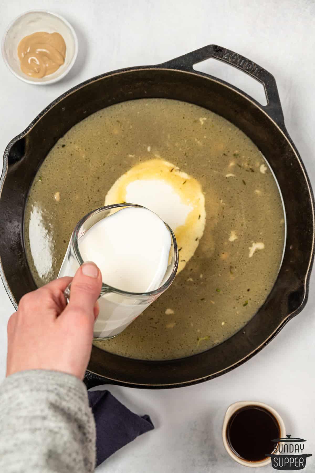 adding cream to sauce for mustard sauce