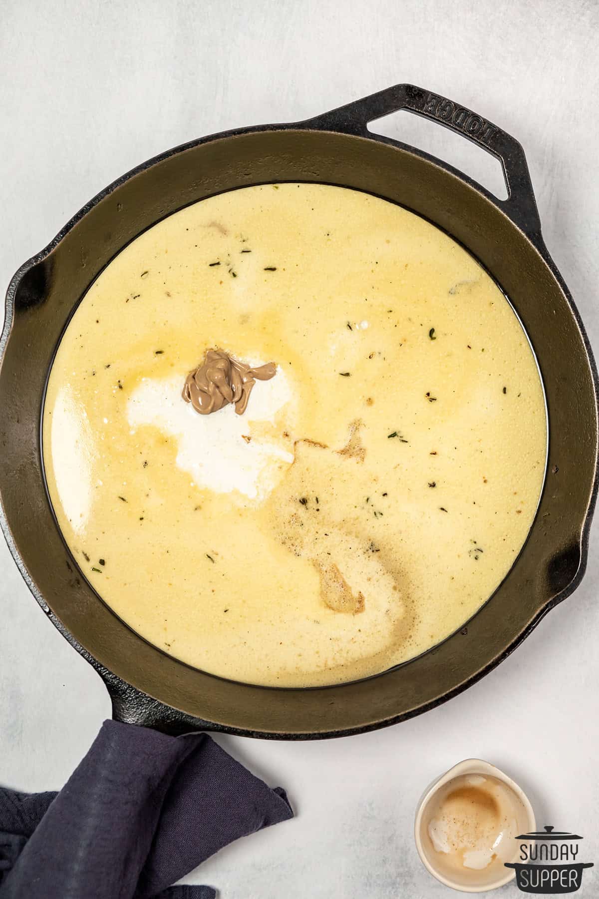 adding mustard to sauce in pan