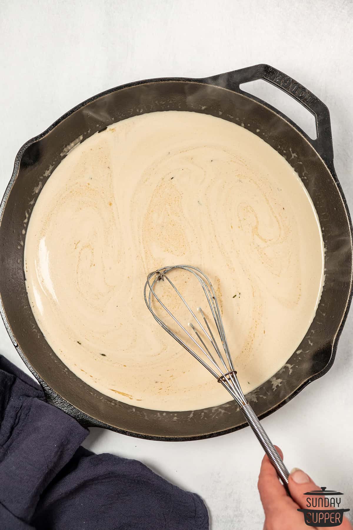 stirring mustard sauce with a whisk