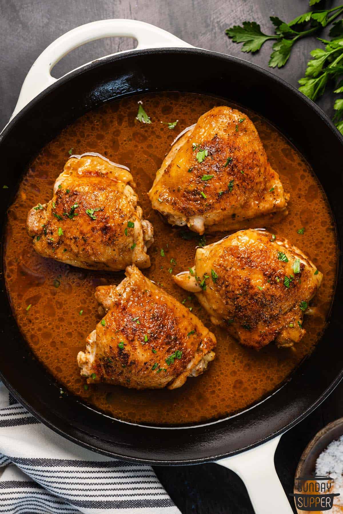 a pan with cooked chicken thighs and sauce