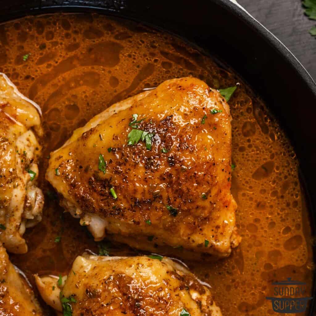 a closeup of a pan seared chicken thigh with sauce