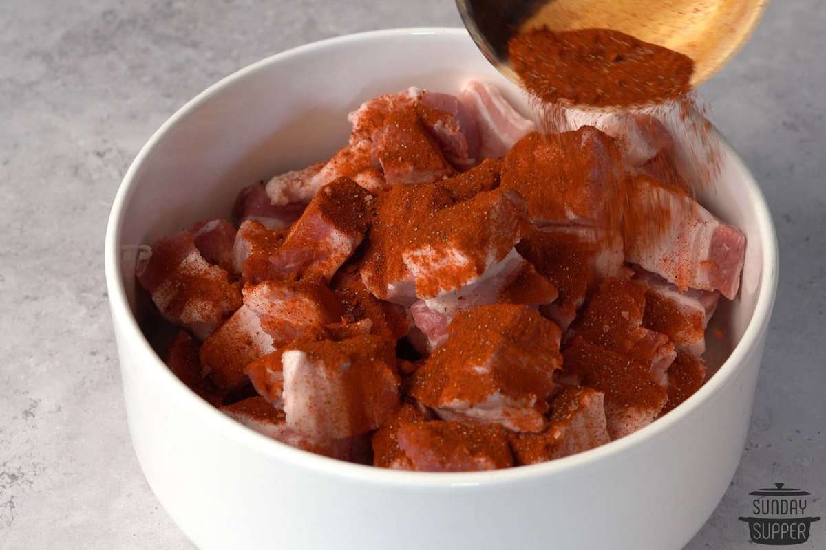 seasoning pork belly in a bowl