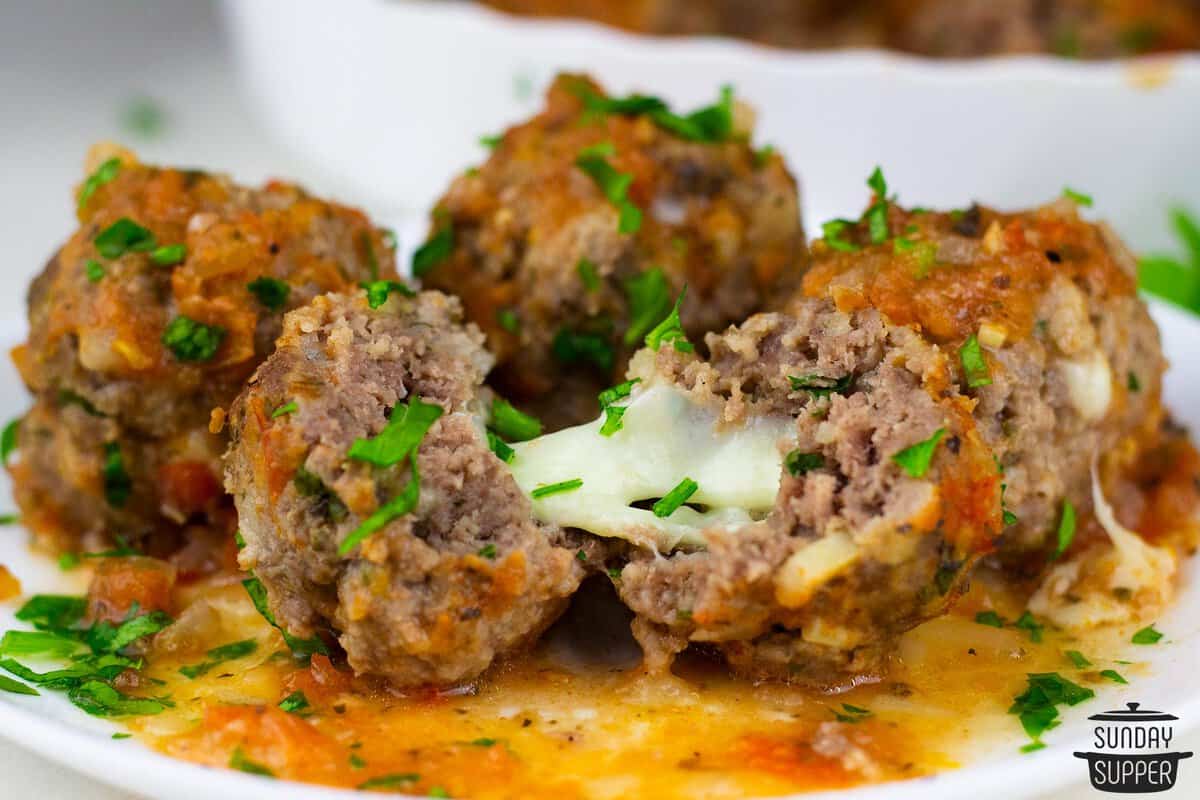 melted cheese in a cut open stuffed meatball