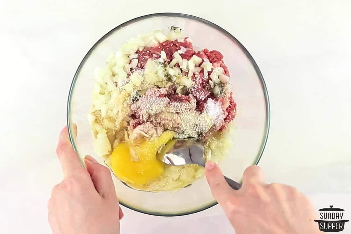 the meatballs being mixed in a bowl