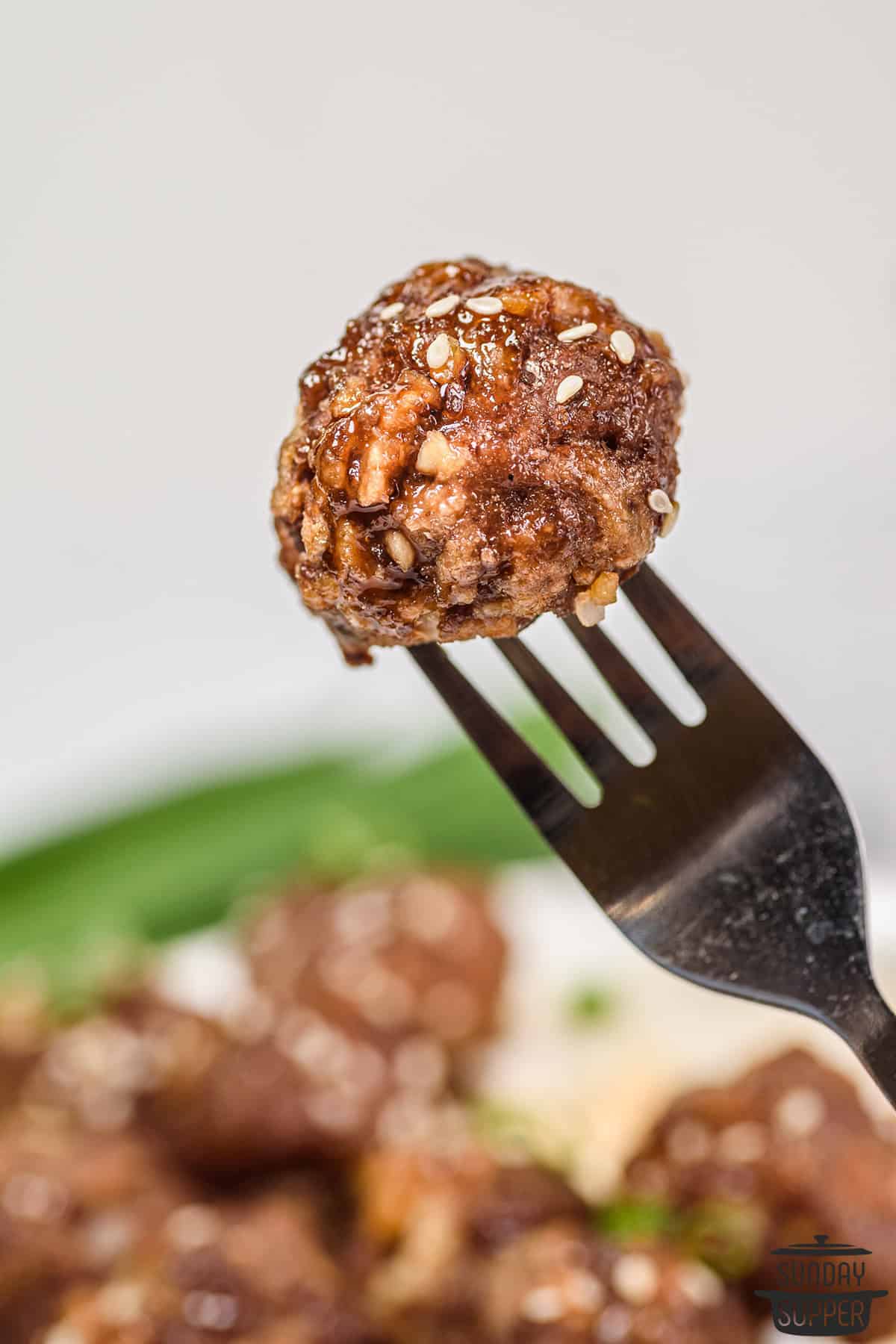 a honey sriracha glazed meatball on a fork