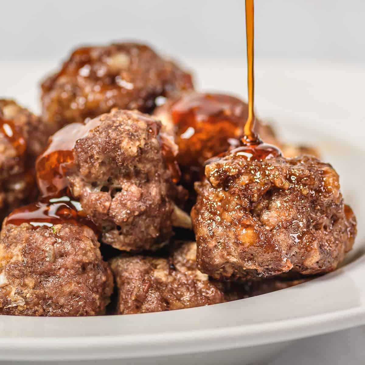 honey sriracha being poured on meatballs