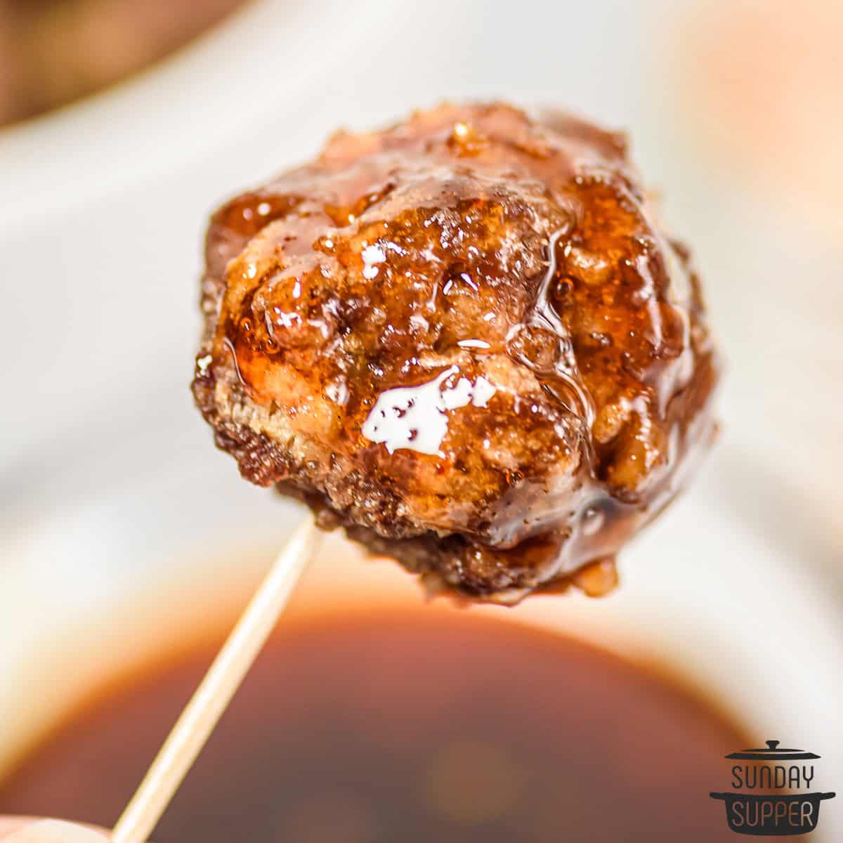 a honey sriracha glazed meatball on a toothpick