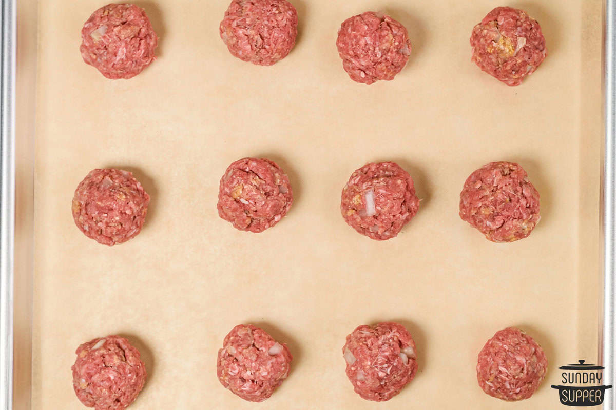 rolled meatballs on a baking sheet