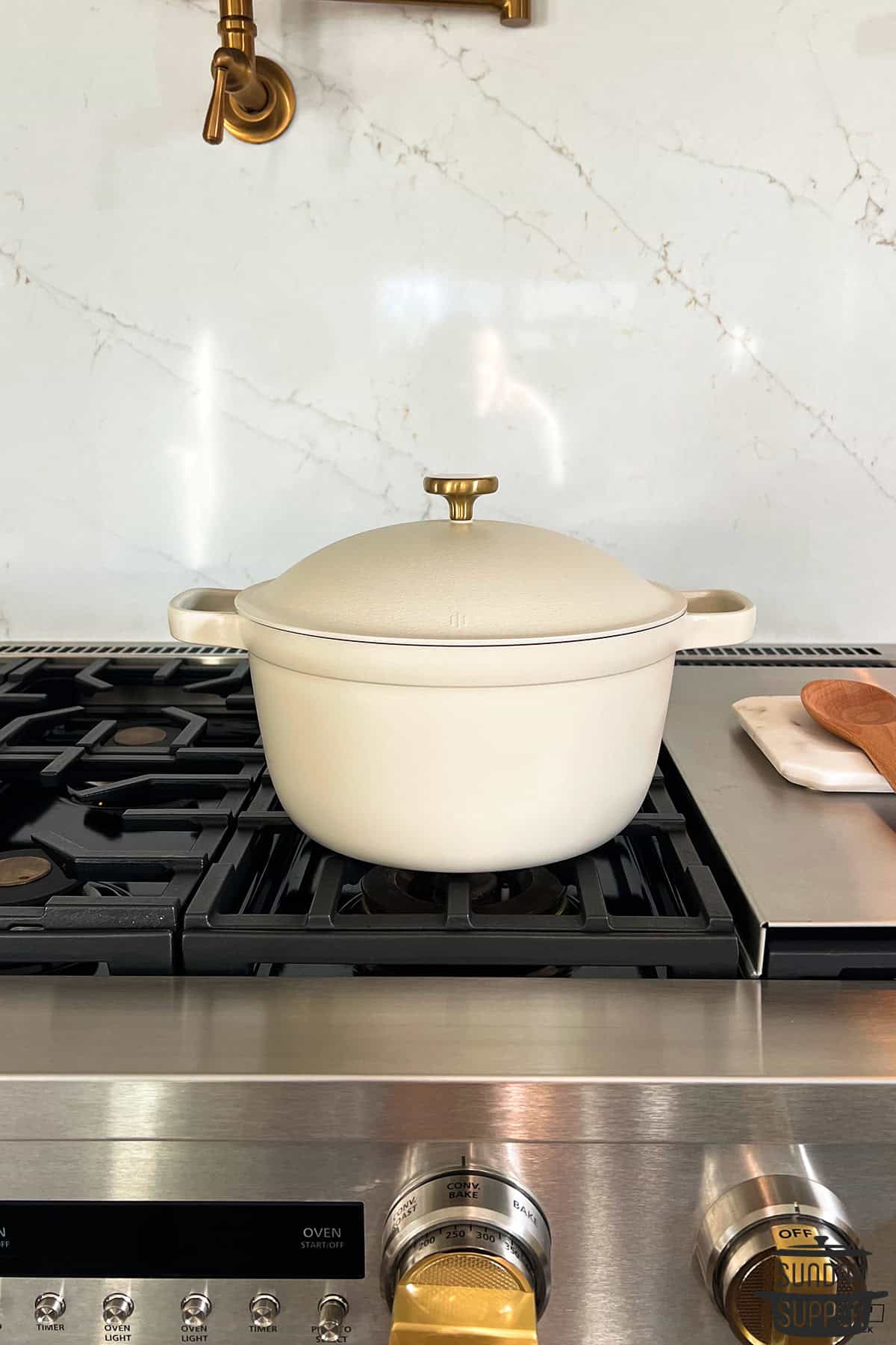 a cream colored dutch oven on a stovetop