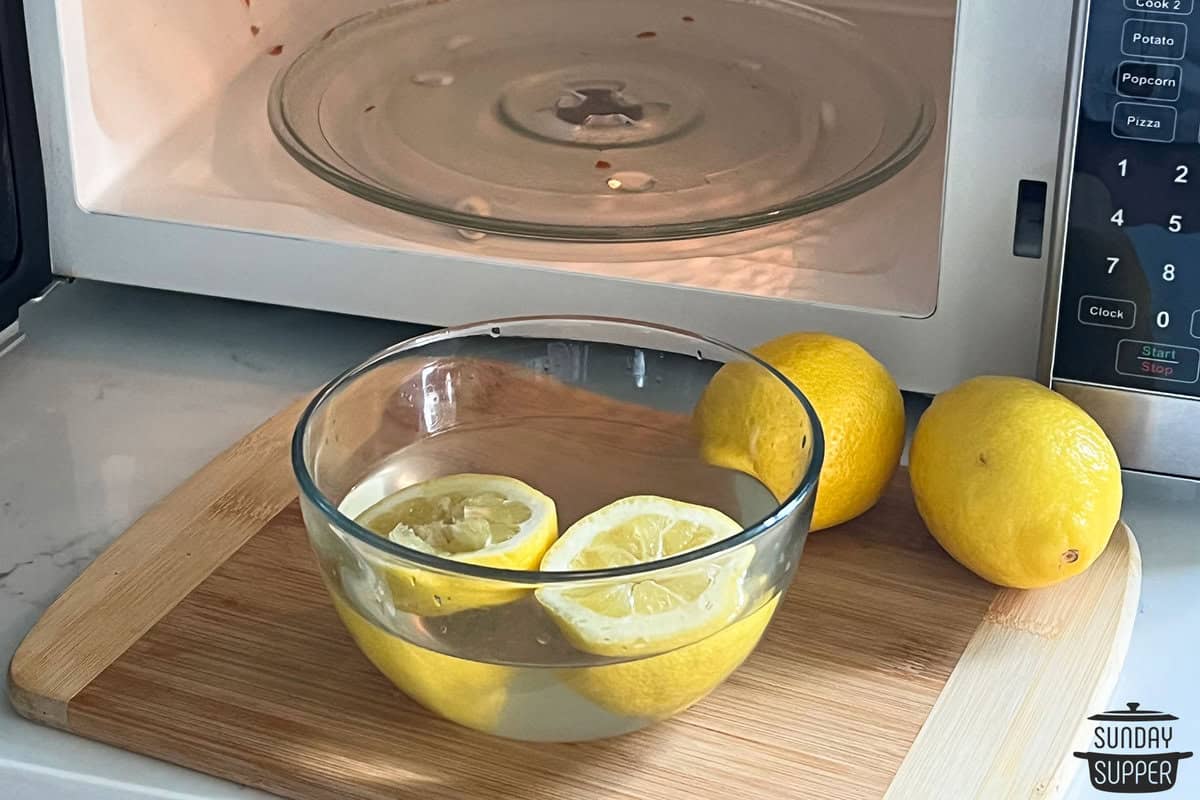 a bowl of water with lemons in it to be microwaved