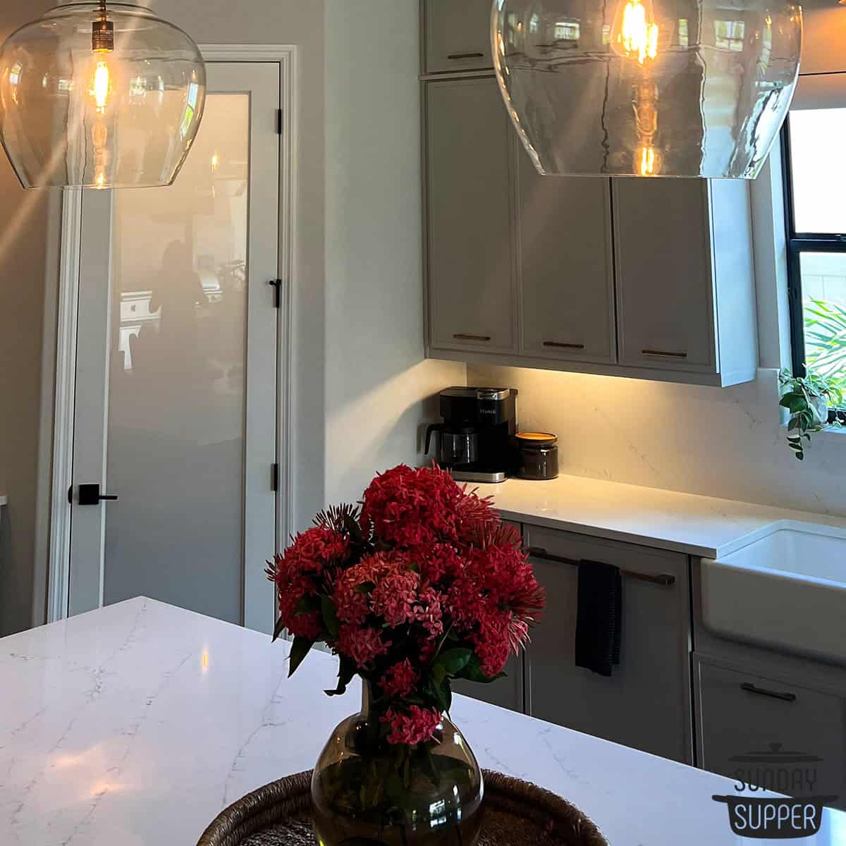 a quartz kitchen island and kitchen counter with decorative flowers