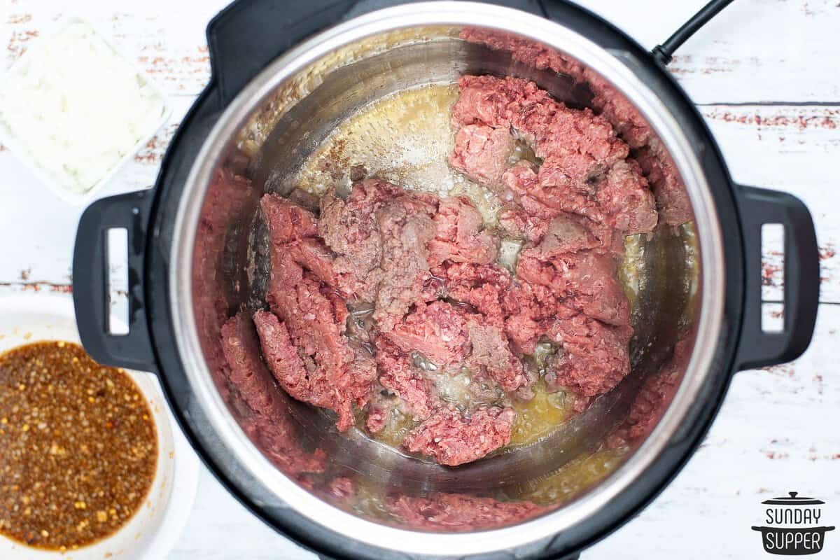 the beef being browned in an instant pot