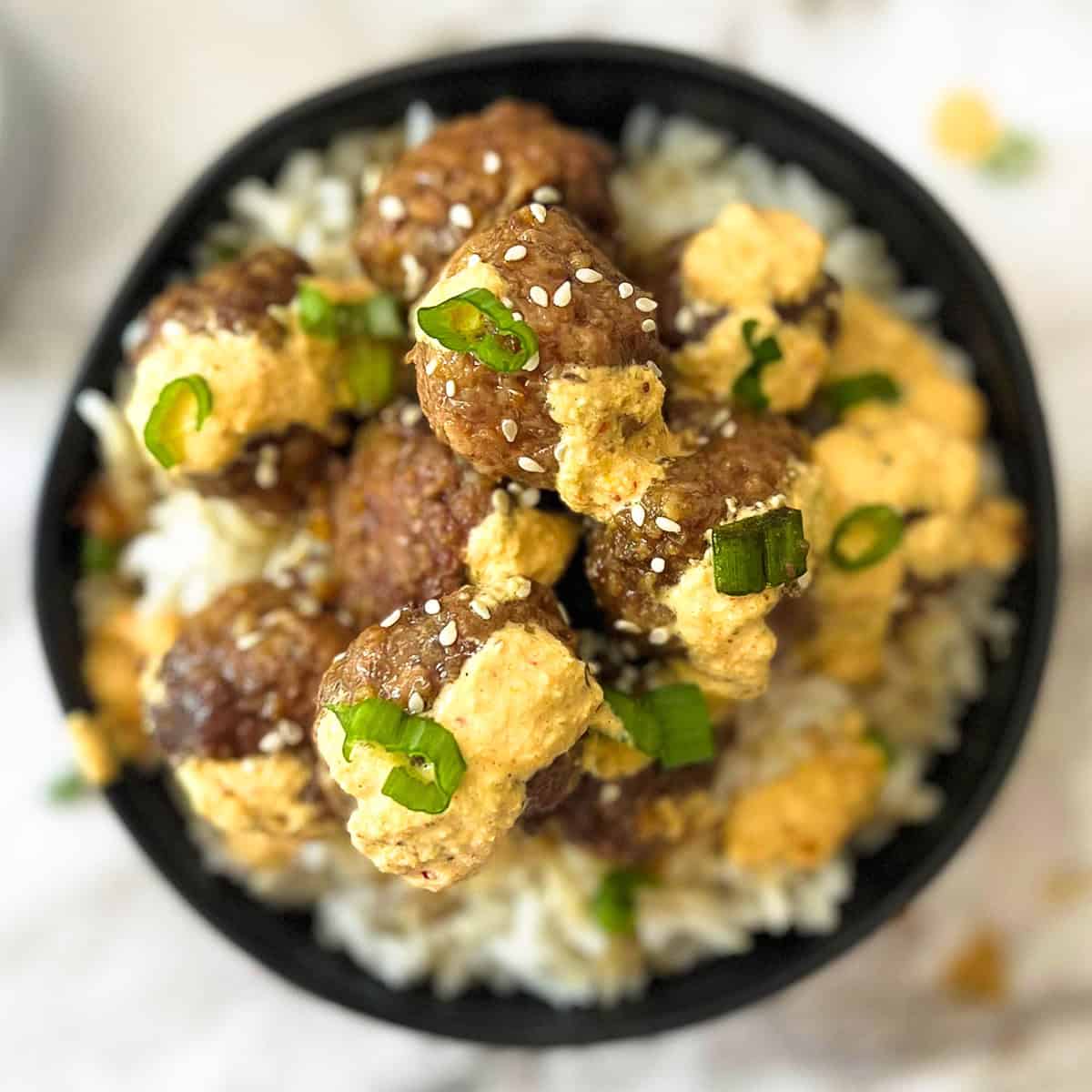 a top down view of a bowl of rice and korean meatballs