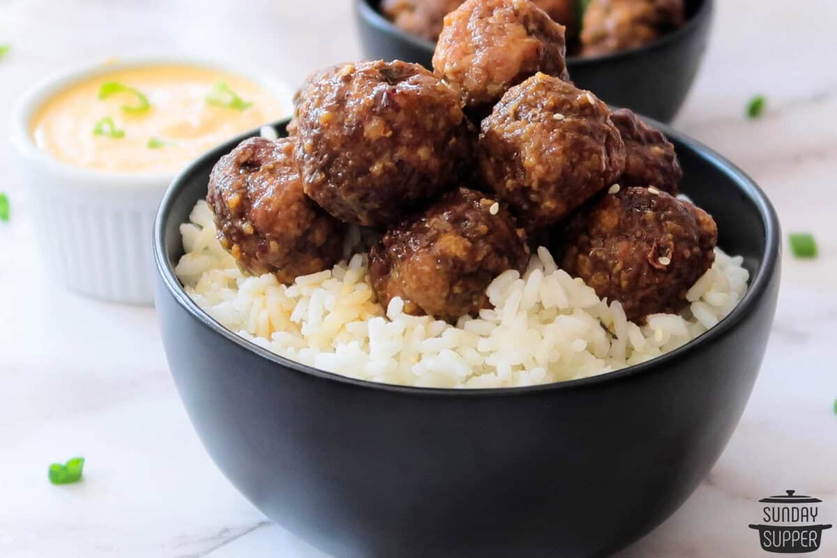 a bowl of white rice piled with bulgogi meatballs to serve