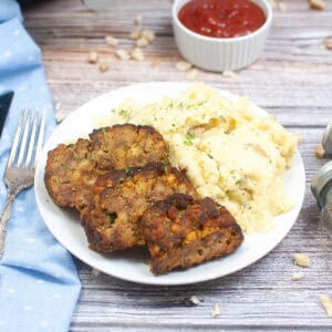 three slices of meatloaf on a plate with mashed potatoes