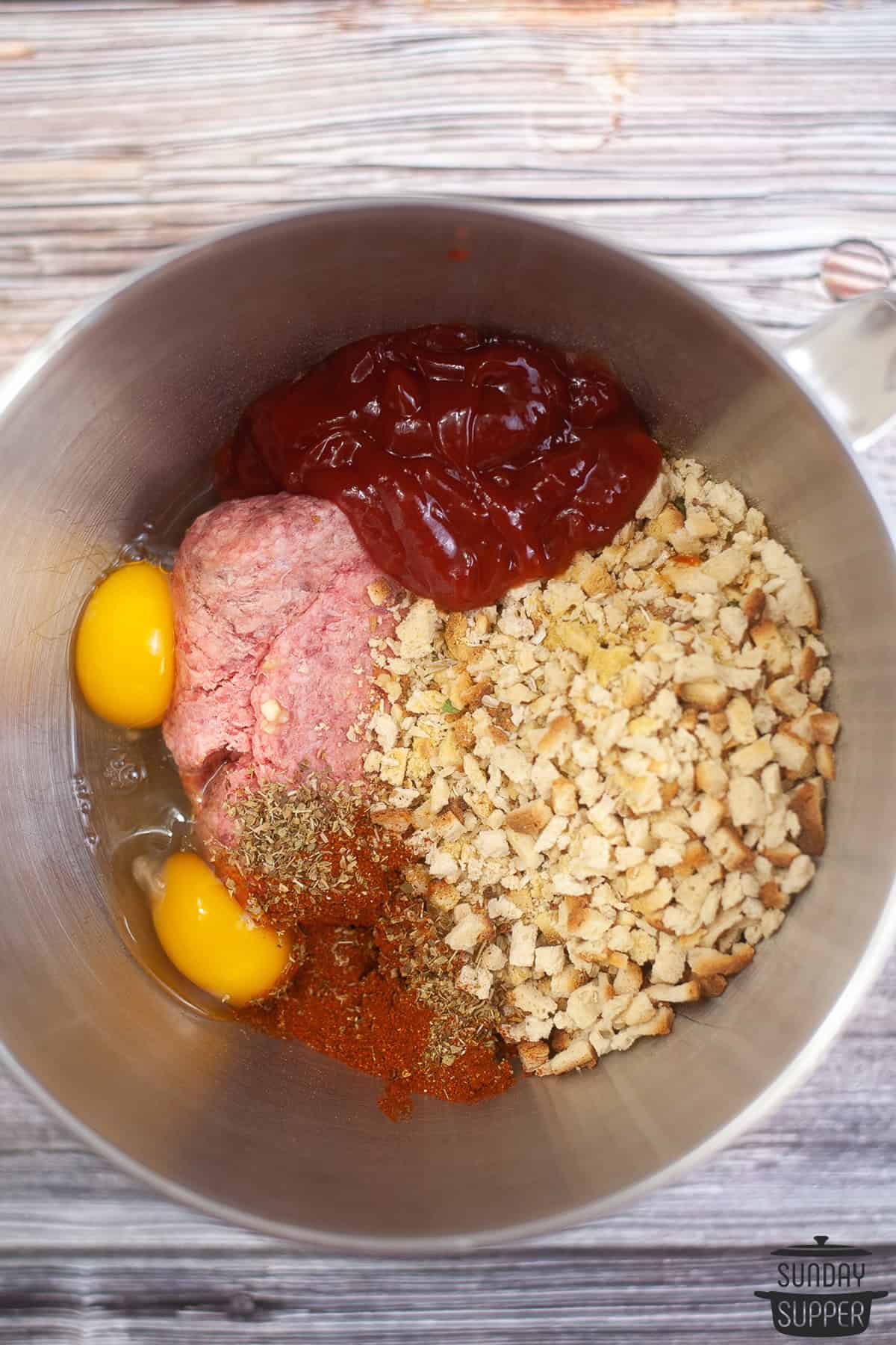 all the ingredients for meatloaf in a mixing bowl