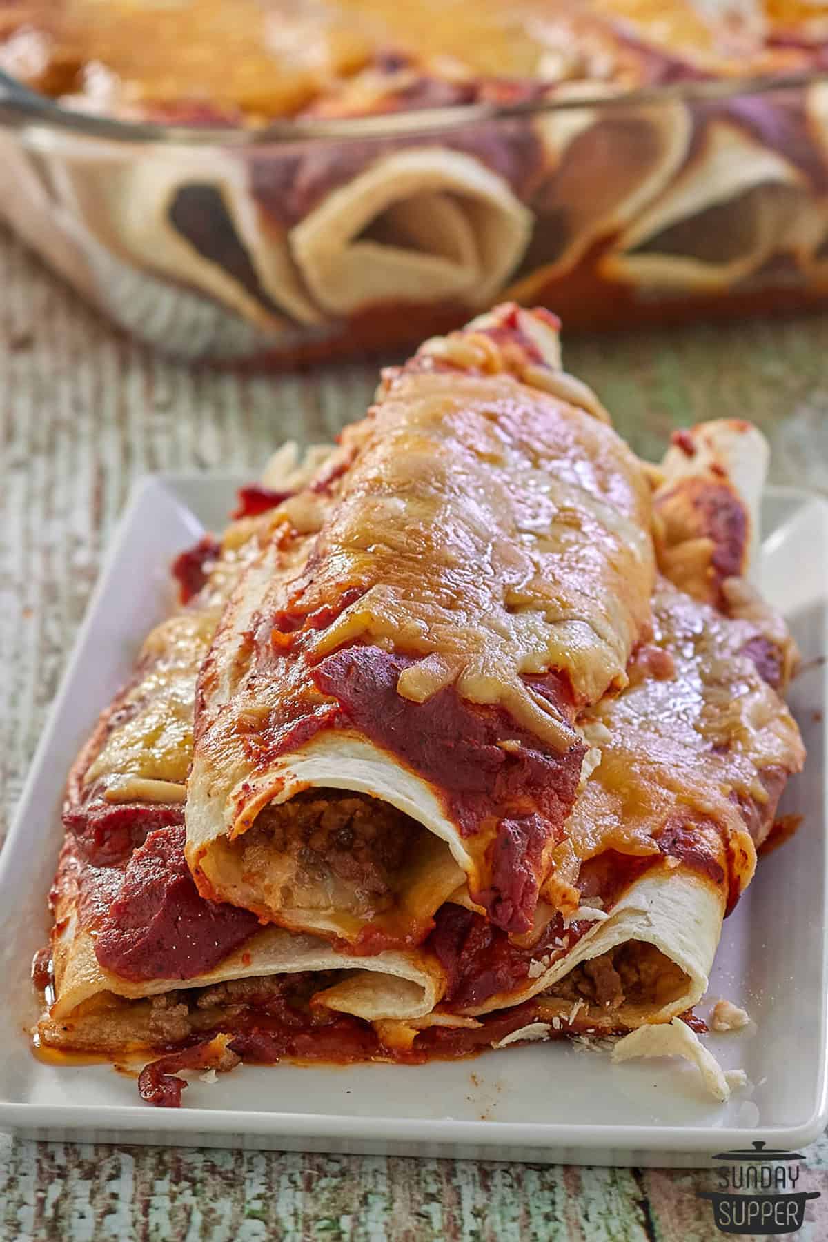 three completed enchiladas on a serving dish