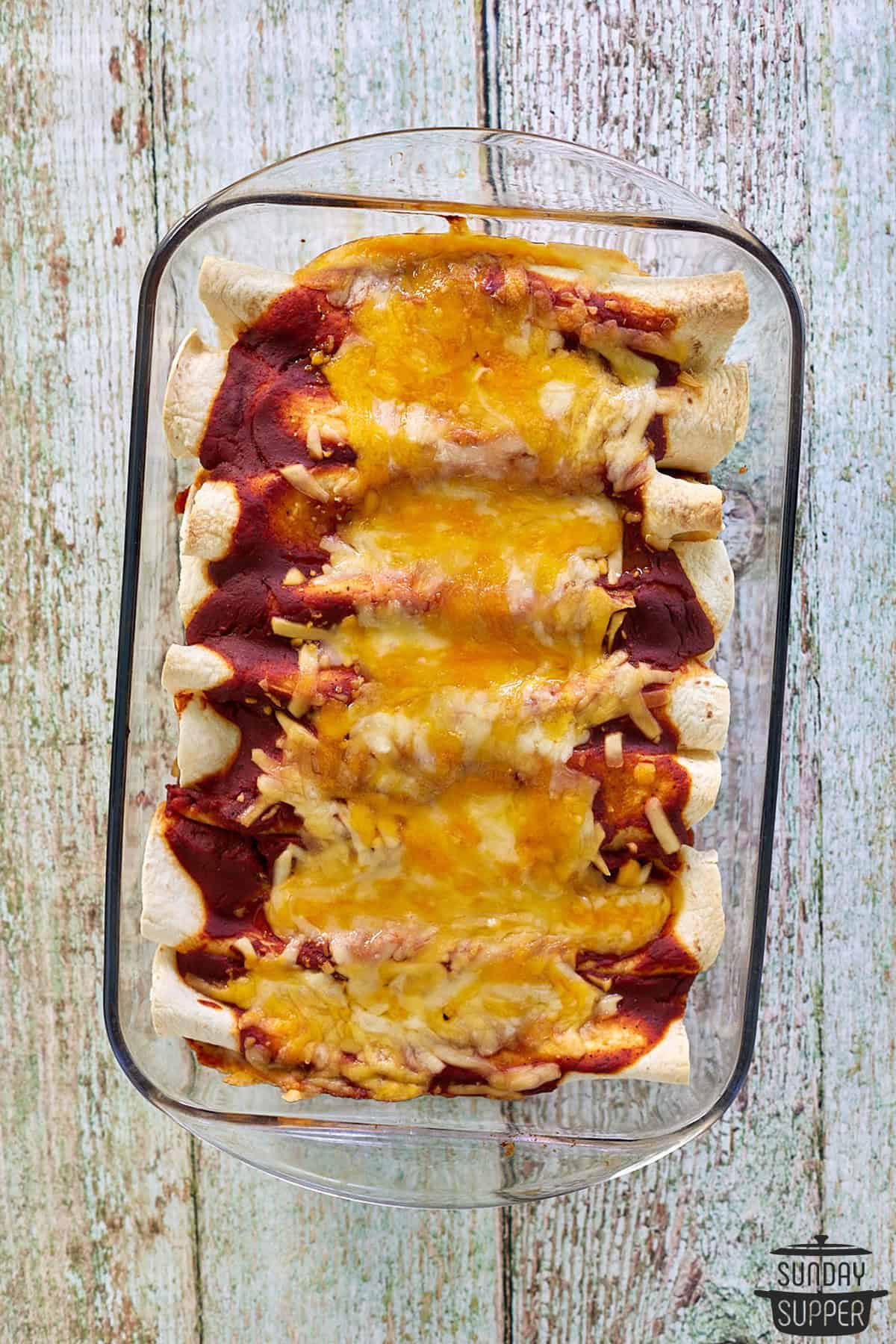 a casserole dish with enchiladas and cheese