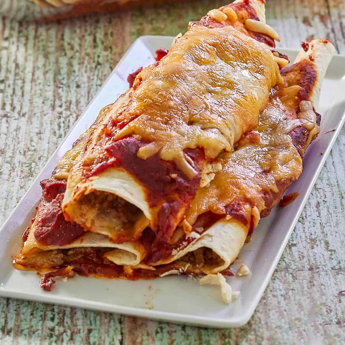 a plate of beef enchiladas with cheese