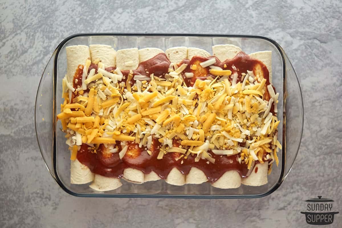 the enchiladas in a casserole dish with sauce and cheese