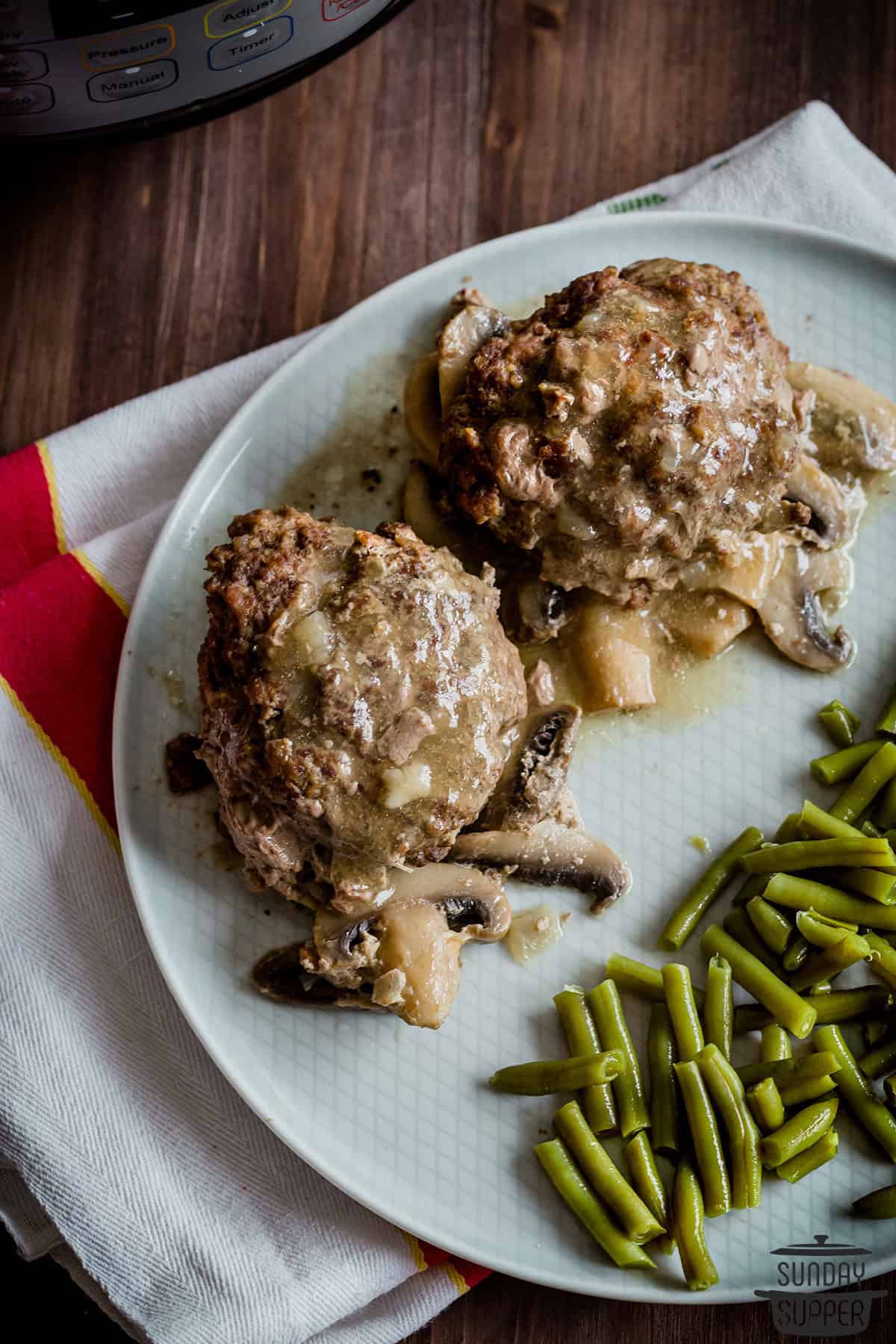 two completed steaks on a plate with gravy