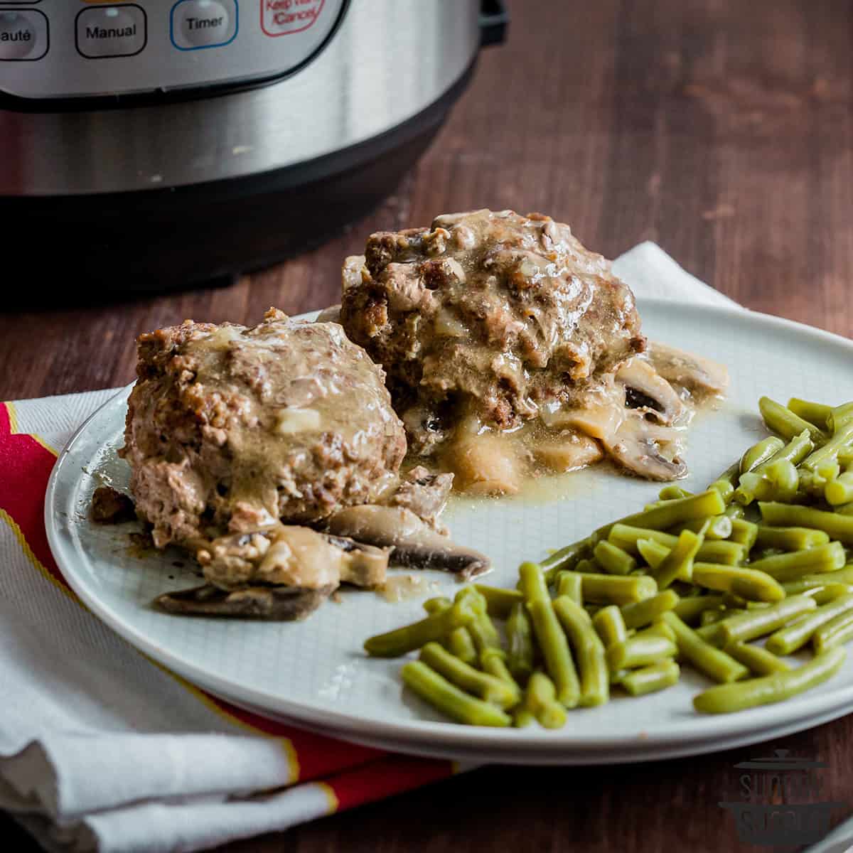 salisbury steaks on a plate with green beans