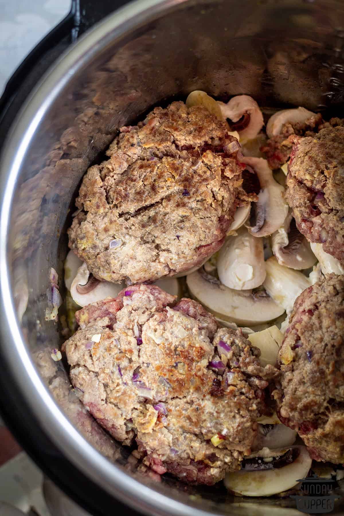 the browned steaks added on top of the mushrooms and onions