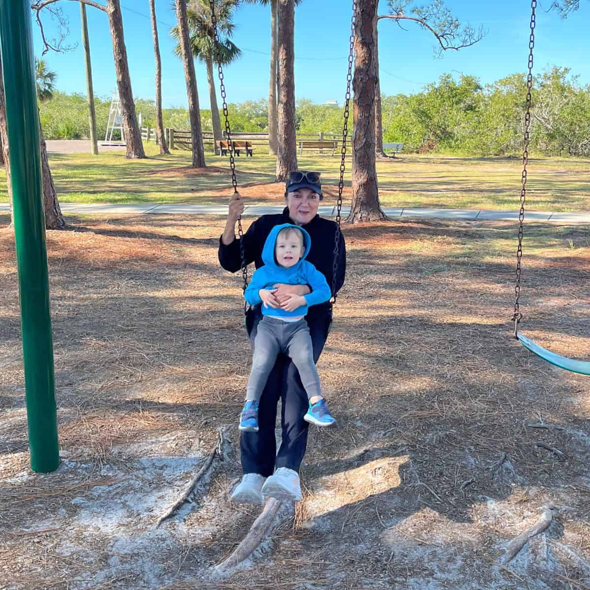 isabel and aiden on a swingset