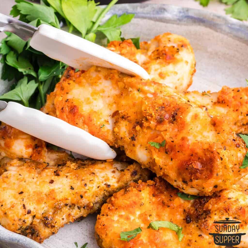 air fryer chicken strips and tongs on a plate