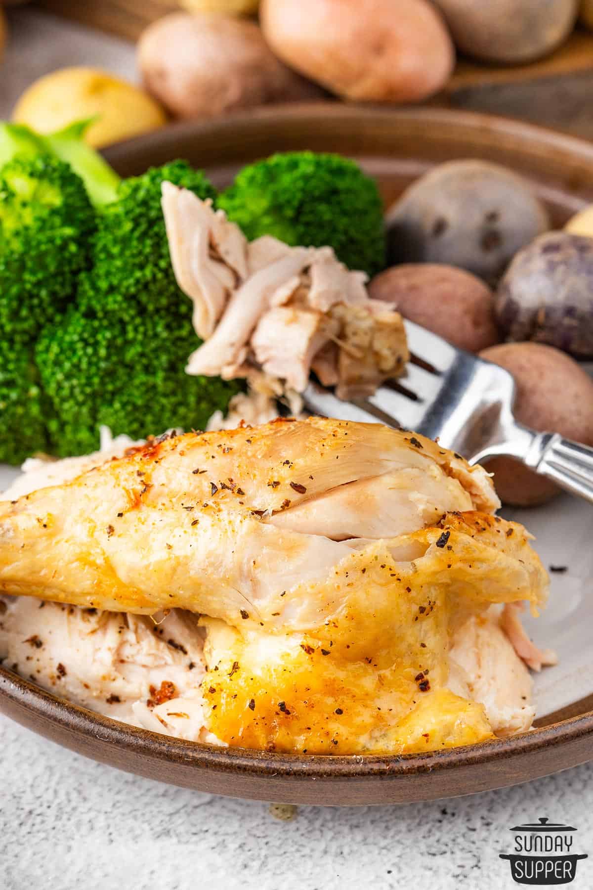 a dinner place with broccoli, potatoes, and air fryer chicken